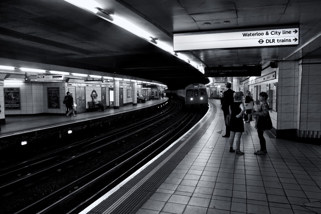 Monochrome shot of subway passengers as they wait for their train on the London Underground.